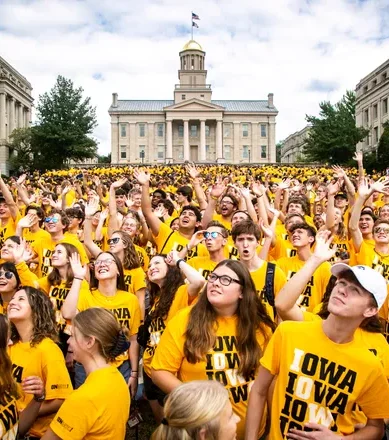 Studenten op de campus van Iowa university Grote groep studenten in gele shirts op de campus van Iowa university tijdens een welkomstactiviteit.