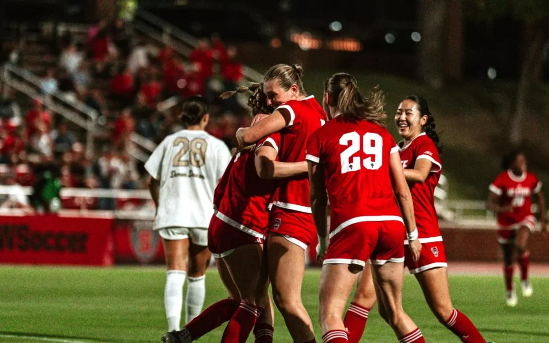 Student-athlete Fien Leijdekker viert een succesmoment met haar voetbalteam van North Carolina State University tijdens een college soccer wedstrijd in Amerika.