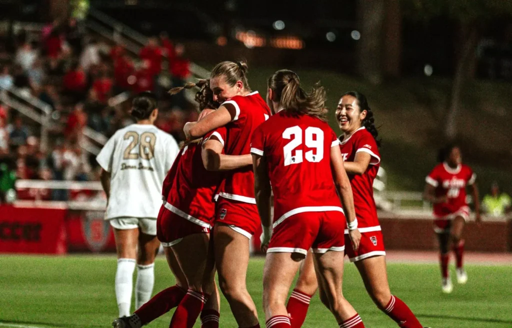 Student-athlete Fien Leijdekker viert een succesmoment met haar voetbalteam van North Carolina State University tijdens een college soccer wedstrijd in Amerika.