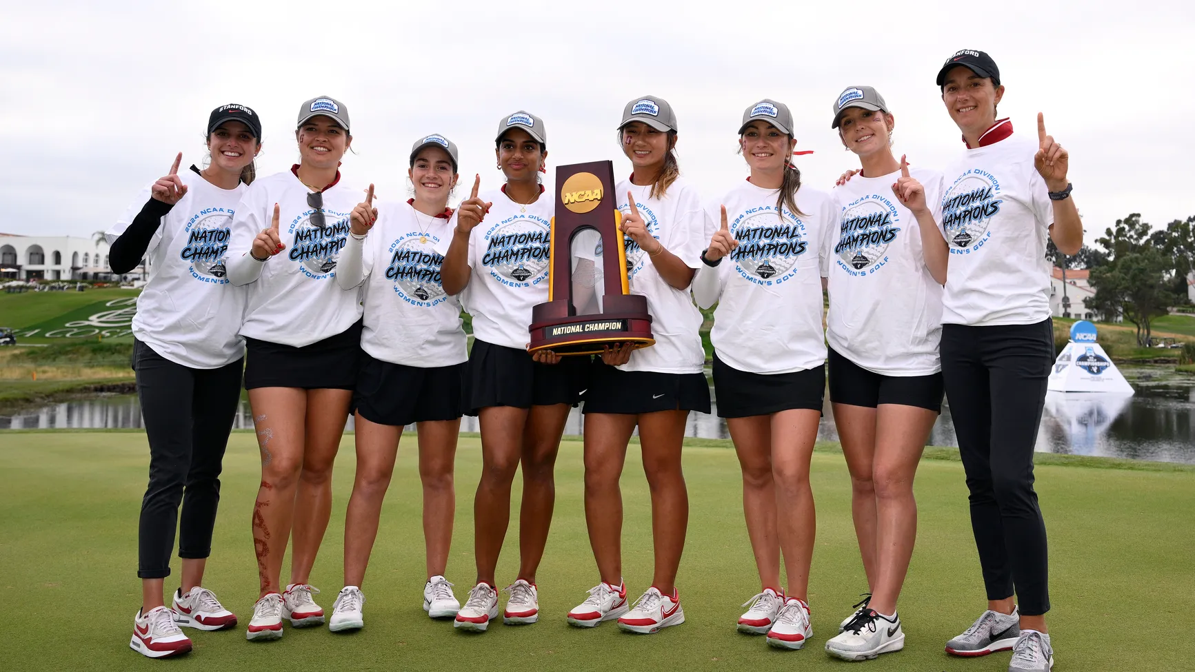 ampioenen gekroond: het succes van een college golf team Het winnende vrouwen college golfteam poseert trots met de NCAA National Championship trofee op de green.
