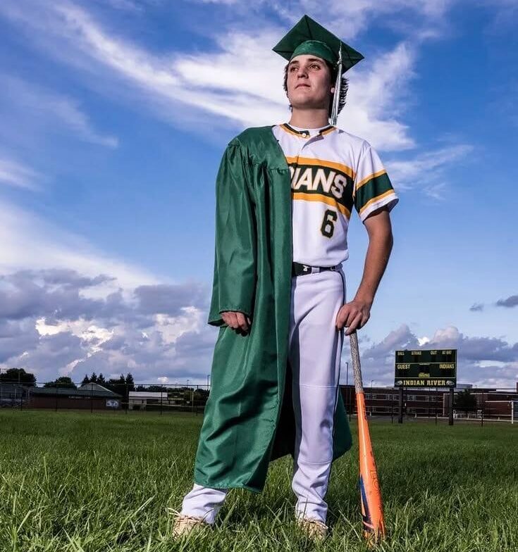 Afstuderen als student-athlete in Amerika College baseball speler viert zijn afstuderen op een baseballveld in Amerika