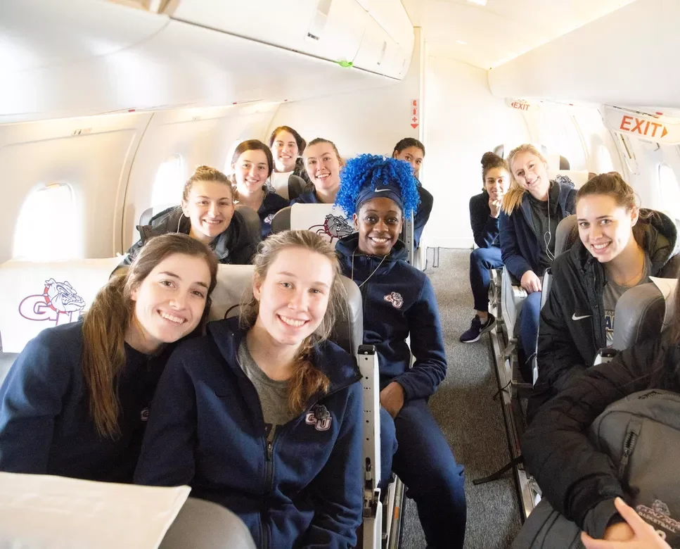 Het Gonzaga Bulldogs dames basketbalteam glimlacht in een privé chartervliegtuig tijdens een binnenlandse reis naar een uitwedstrijd in Amerika.