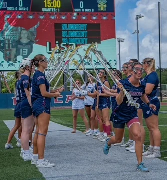 Lisa Slinkert | College Lacrosse bij St. Thomas University Lisa Slinkert rent door een erehaag van teamgenoten tijdens een wedstrijd van St. Thomas University in Miami, Florida.